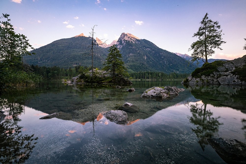 Tre karlar med en fotoutrustning i Alperna